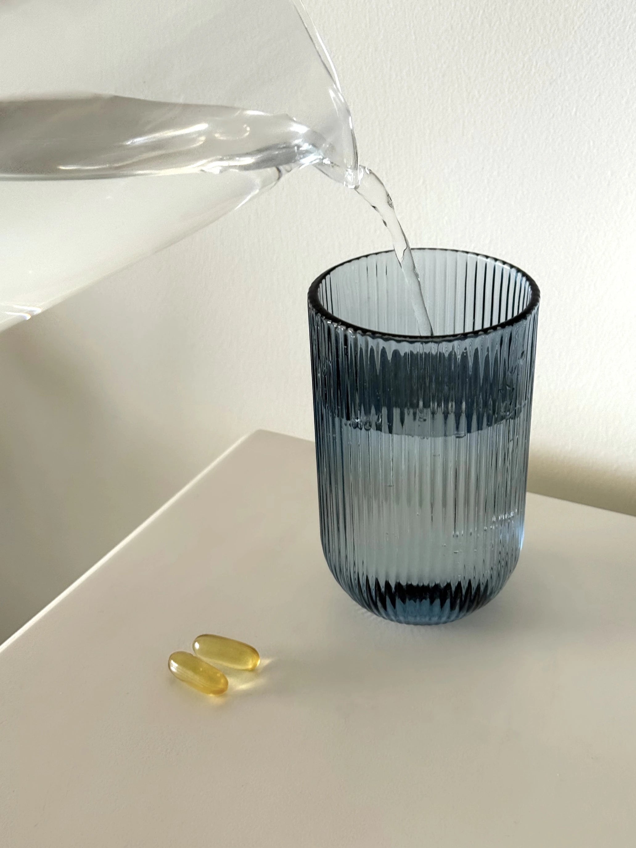 dos-cápsulas-amarillas-de-omega-3-epa-dha-vaso-agua