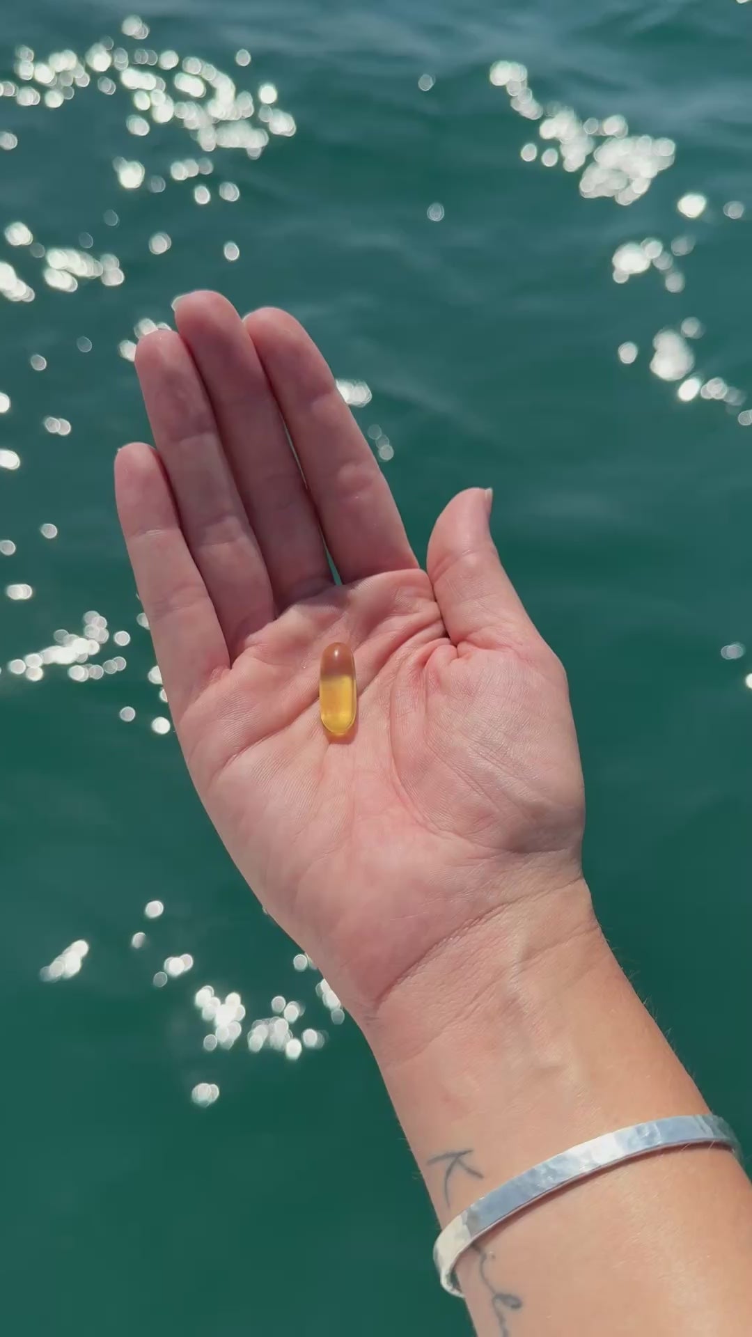 cápsula-de-omega-3-mano-fondo-oceánico